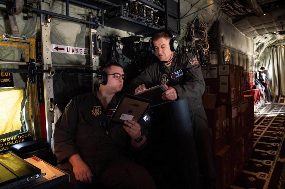 U.S. Air Force Reserve 53rd Weather Reconnaissance Squadron Chief Master Sgt. Rick Cumbo, center, who is chief loadmaster on the “Hurricane Hunters” C-130 Super Hercules mission Tuesday, Jan. 28, 2020, talks with Senior Airman Donny Arseneaux, also a loadmaster, during their flight out of Travis Air Force Base in Fairfield. The two communicate while airborne over the Pacific Ocean.