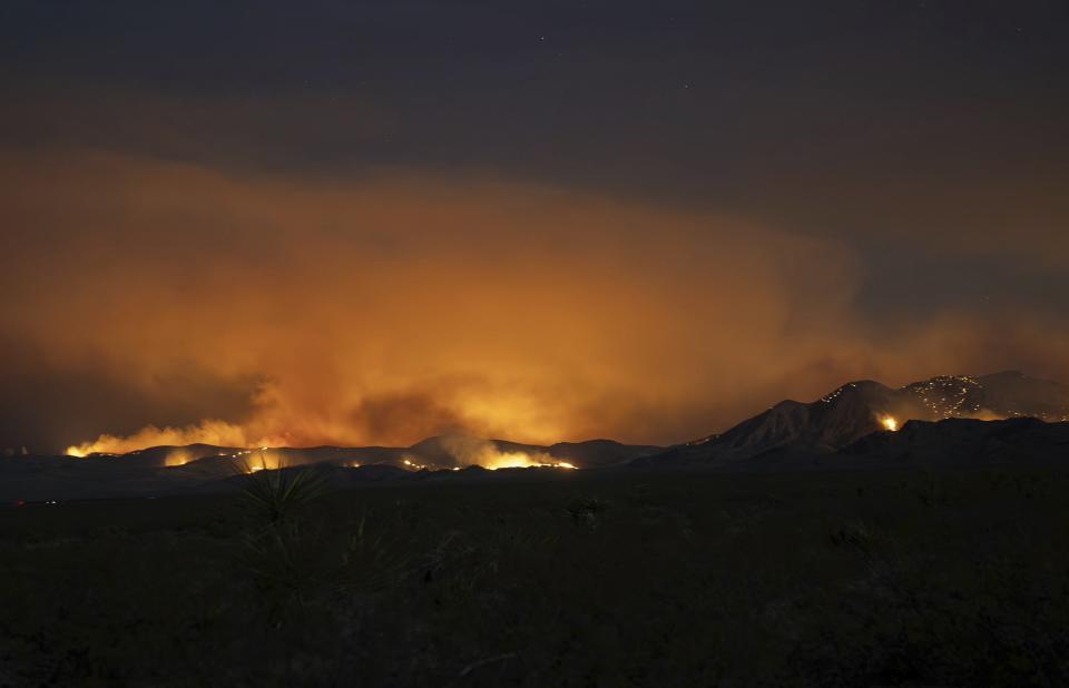In this photo provided by the National Park Service Mojave National Preserve, the York fire burns in the background on the Mojave National Preserve on Saturday, July 29, 2023. A massive wildfire burning out of control in California's Mojave National Preserve is spreading rapidly amid erratic winds. Meanwhile, firefighters reported some progress Sunday against another major blaze to the southwest that prompted evacuations. (C. Willoughby/National Park Service Mojave National Preserve via AP)