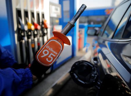 A worker holds a fuel nozzle at a Gazprom Neft petrol station in Moscow, Russia, March 11, 2016. REUTERS/Maxim Shemetov/File Photo