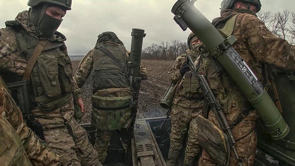 In this photo taken from video released by Russian Defense Ministry Press Service on Tuesday, April 9, 2024, Russian Army soldiers ride their armoured vehicle to take positions and fire from flamethrowers toward Ukrainian positions at an undisclosed location in Ukraine. (Russian Defense Ministry Press Service via AP)