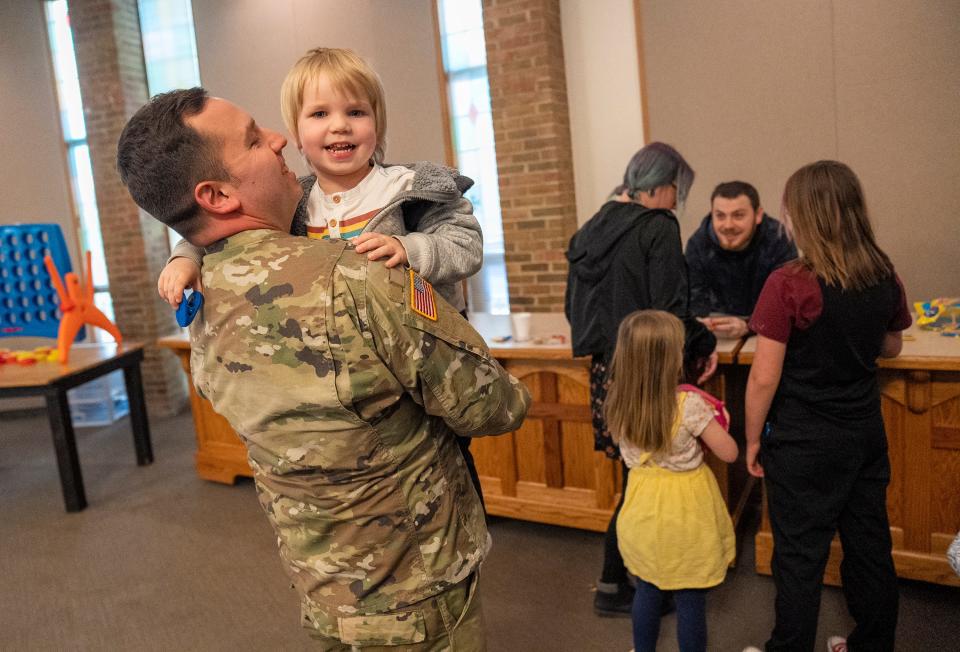 Ohio Army National Guard Staff Sgt. Jesse Hickey holds his son Cole Hickey, 3, following a duty ceremony for deploying soldiers Friday at the Reynoldsburg Community Church.