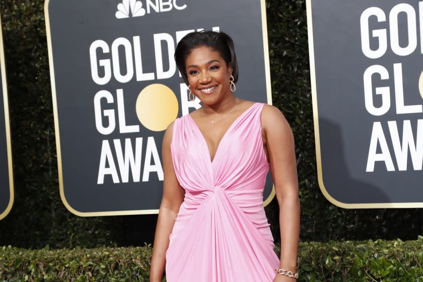 A woman posing in a light pink gown