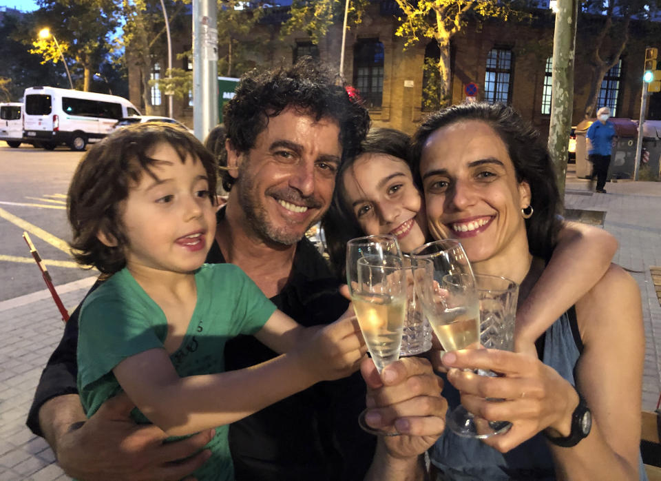 El fotógrafo Emilio Morenatti festeja con su esposa Marta Ramoneda y sus hijos Pau, izquierda, y Gala en Barcelona el viernes 11 de junio de 2021 tras enterarse de que ganó el premio Pulitzer en la categoría de fotorreportaje. (AP Foto/Kyle Mawer)