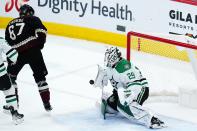 Dallas Stars goaltender Jake Oettinger (29) makes a save on a deflected shot by Arizona Coyotes left wing Lawson Crouse (67) during the first period of an NHL hockey game Sunday, Feb. 20, 2022, in Glendale, Ariz. (AP Photo/Ross D. Franklin)