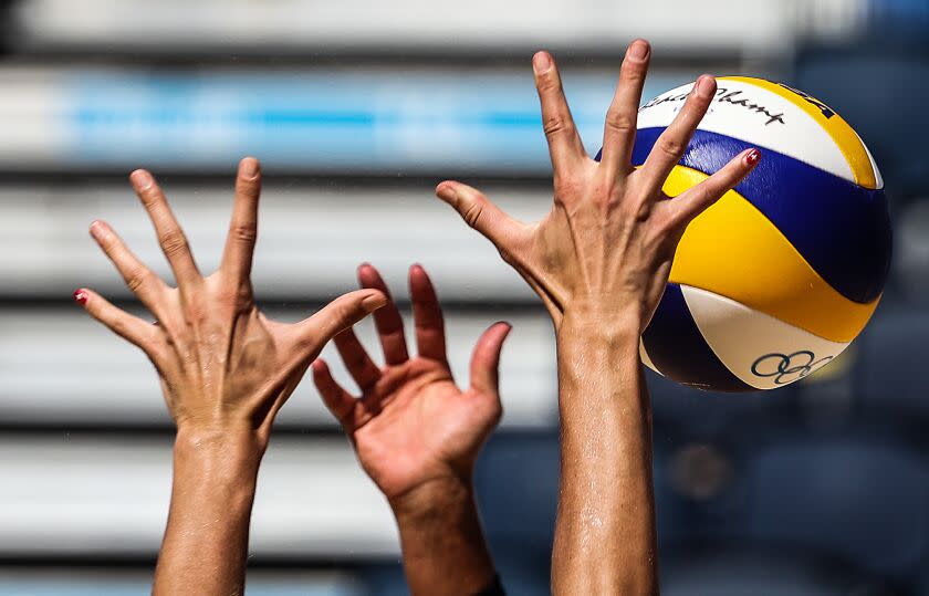 Tokyo, Japan,Thursday, August 5, 2021 - Alix Klineman stretches her fingers to the limit in an attempt to block the spike of Switzerland's Joana Heidrich at the Tokyo 2020 Olympics Beach Volleyball at Shiokaze Park. (Robert Gauthier/Los Angeles Times)