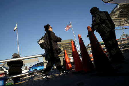 A commuter walks by a U.S. Customs and Border Protection (CBP) agent as she crosses into El Paso, Texas, at Paso del Norte international border crossing bridge, in Ciudad Juarez, Mexico April 1, 2019. REUTERS/Jose Luis Gonzalez