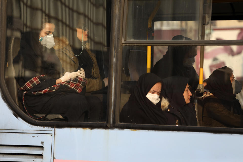 Woman, wearing face masks, travel on a public bus in a street in western Tehran, Iran, Saturday, Feb. 29, 2020. Iran is preparing for the possibility of "tens of thousands" of people getting tested for the new coronavirus as the number of confirmed cases spiked again Saturday, Health Ministry spokesman Kianoush Jahanpour said, underscoring the fear both at home and abroad over the outbreak in the Islamic Republic. (AP Photo/Vahid Salemi)