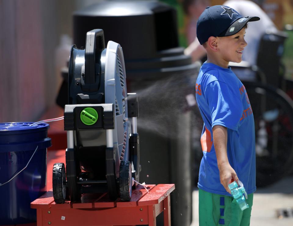 Sawyer Bazillion, 6, of Leominster, Mass. loves the mister in the kids area of Polar Park.  The Heat wave continued for hearty WooSox fans braving 90 degree weather on Sunday, July 24, 2022.