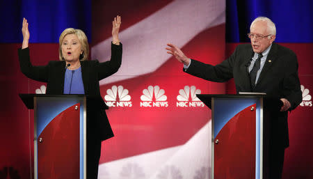 Hillary Clinton and rival candidate Bernie Sanders speak simultaneously January 17, 2016. REUTERS/Randall Hill