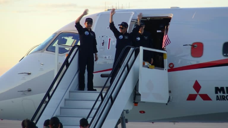 Crew members of the Mitsubishi Regional Jet wave upon their arrival on September 28, 2016 at Grant County international airport in Washington, after flying from Anchorage, Alaska