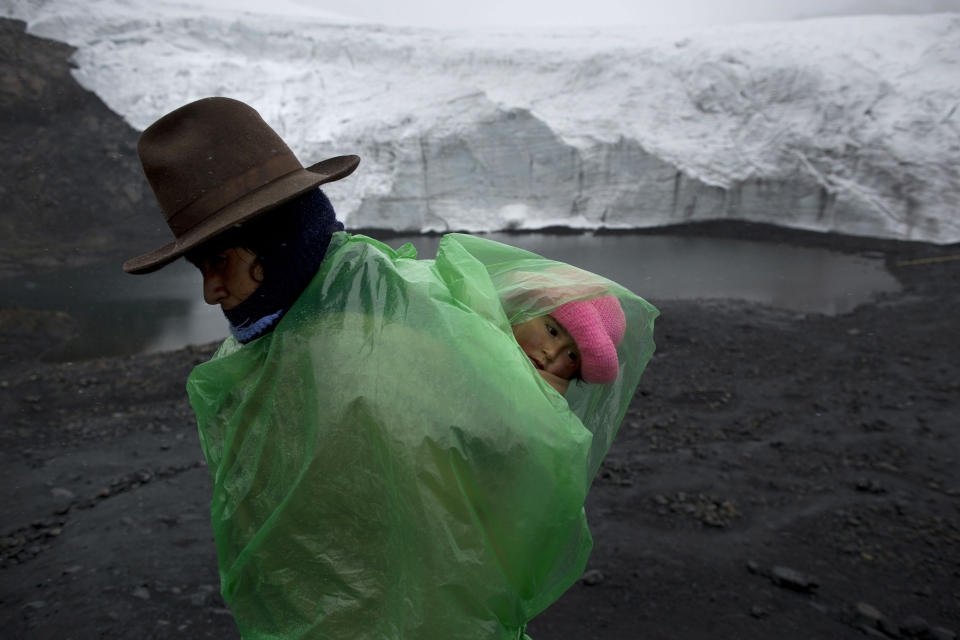 <p>Fausta Ortiz, 38, stands guard over the Pastoruri glacier while carrying her daughter Lisoyun, 2, in Huaraz, Peru, Dec. 4, 2014. According to Alejo Cochachin, coordinator of the glaciology unit, the Pastoruri glacier retreated 576 meters between 1980 and 2014. Peru’s glaciers have lost more one-fifth of their mass in just three decades, and 70 percent of the 30 million people in Peru who inhabit the Pacific coastal desert depend on glacial runoff for hydropower and to irrigate crops. This means their electricity and long-term food security could also be at risk. Higher alpine temperatures are killing off plant and animal species in cloud forests, and scientists predict Pacific fisheries will suffer. (Photo: Rodrigo Abd/AP) </p>