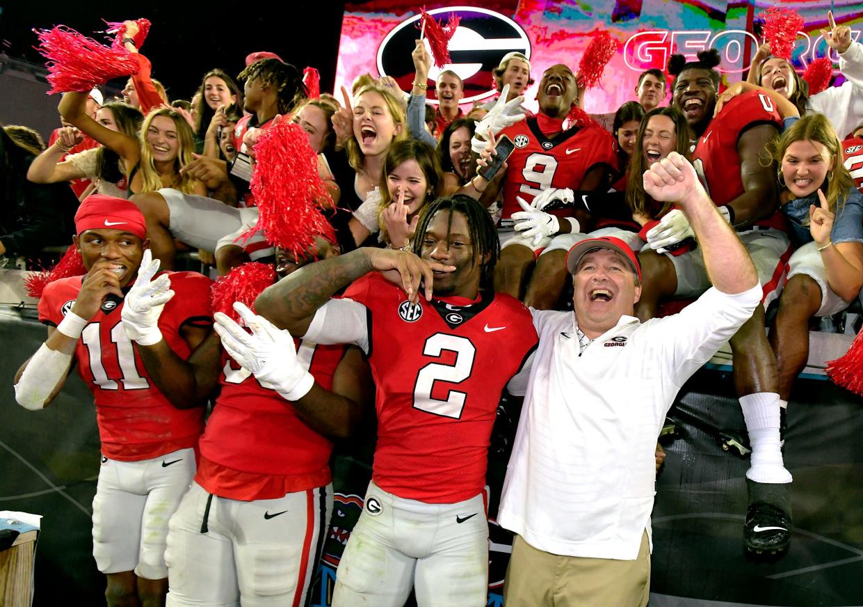 Georgia football coach Kirby Smart (lower right) celebrates Saturday's 42-20 victory over the Florida Gators with his players, at TIAA Bank Field.