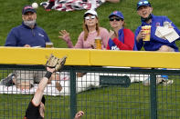 FILE - Fans watch as San Francisco Giants' Mike Yastrzemski catches a deep fly-out hit by Chicago Cubs' Joc Pederson during the third inning of a spring training baseball game, Friday, March 26, 2021, in Mesa, Ariz. Spring training games might not count in the official standings, but they certainly count for the pocketbooks of business owners in Arizona and Florida. They're also a much-anticipated destination for fans who come for the warm sunshine and the laid-back atmosphere.(AP Photo/Matt York, File)