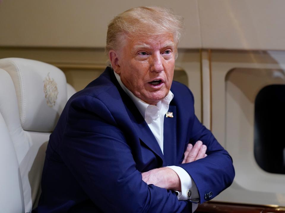 Former President Donald Trump speaks with reporters while in flight on his plane