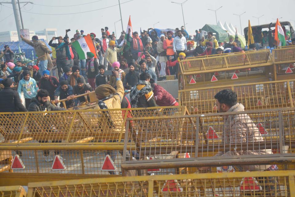 NEW DELHI, INDIA - JANUARY 26: Demonstrators breaking past police barricades while heading into the capital during a tractor rally on Republic Day, at Ghazipur on January 26, 2021 in New Delhi, India. Major scenes of chaos and mayhem at Delhi borders as groups of farmers allegedly broke barricades and police check posts and entered the national capital before permitted timings. Police used tear gas at Delhi's Mukarba Chowk to bring the groups under control. Clashes were also reported at ITO, Akshardham. Several rounds of talks between the government and protesting farmers have failed to resolve the impasse over the three farm laws. The kisan bodies, which have been protesting in the national capital for almost two months, demanding the repeal of three contentious farm laws have remained firm on their decision to hold a tractor rally on the occasion of Republic Day. (Photo by Sakib Ali/Hindustan Times via Getty Images)