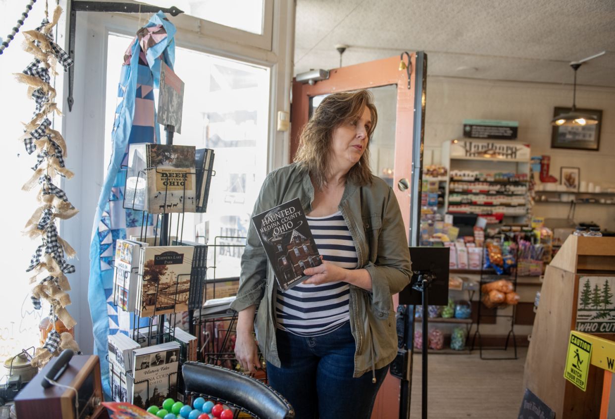 Beverly Scandlon, owner of Chatham General Store since 2020, with some of the Medina County store's available items, including local books.