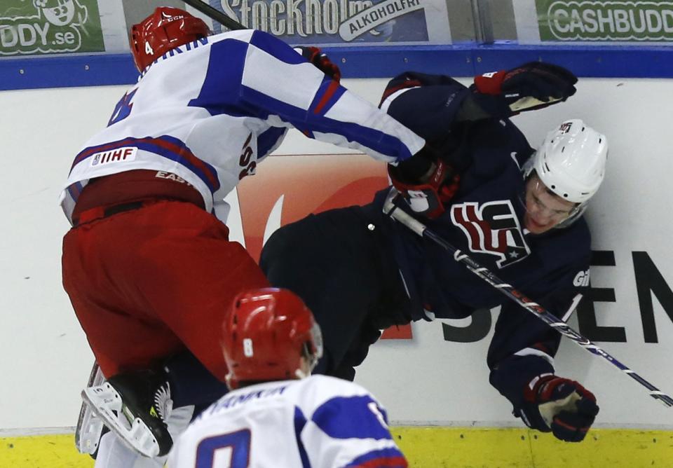 Russia's Ilya Lyubushkin (L) checks Nicolas Kerdiles of the U.S. during their quarter-final game at the IIHF World Junior Championship ice hockey game in Malmo, Sweden, January 2, 2014. REUTERS/Alexander Demianchuk (SWEDEN - Tags: SPORT ICE HOCKEY)