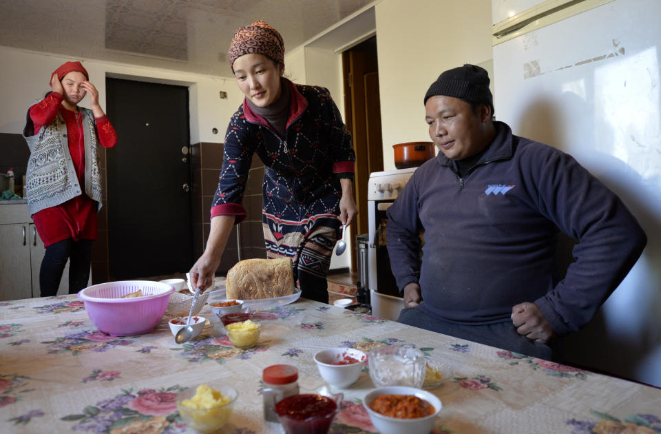 Adilet Kaliyev sits while his wife Burul, center, serves a lunch for him before his heading to the mountains to drive a flock of sheeps at their family house in Tash Bashat village, about 24 kilometers (15 miles) southeast of Bishkek, Kyrgyzstan, Saturday, Oct. 17, 2020. Zarina, wife of his brother Azret Kaliyev in on the left. Kyrgyzstan, one of the poorest countries to emerge from the former Soviet Union, saw its president forced out by protesters earlier this month, but the political turmoil hasn't touched that village nestled in the scenic Ala-Too mountains where life follows centuries-old rites. (AP Photo/Vladimir Voronin)