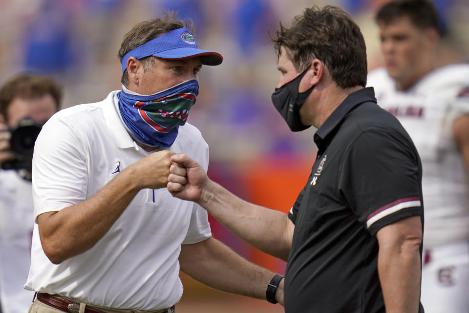 Florida head coach Dan Mullen, left, and South Carolina head coach Will Muschamp bump fists at the end of an NCAA college football game, Saturday, Oct. 3, 2020, in Gainesville, Fla. (AP Photo/John Raoux, Pool)