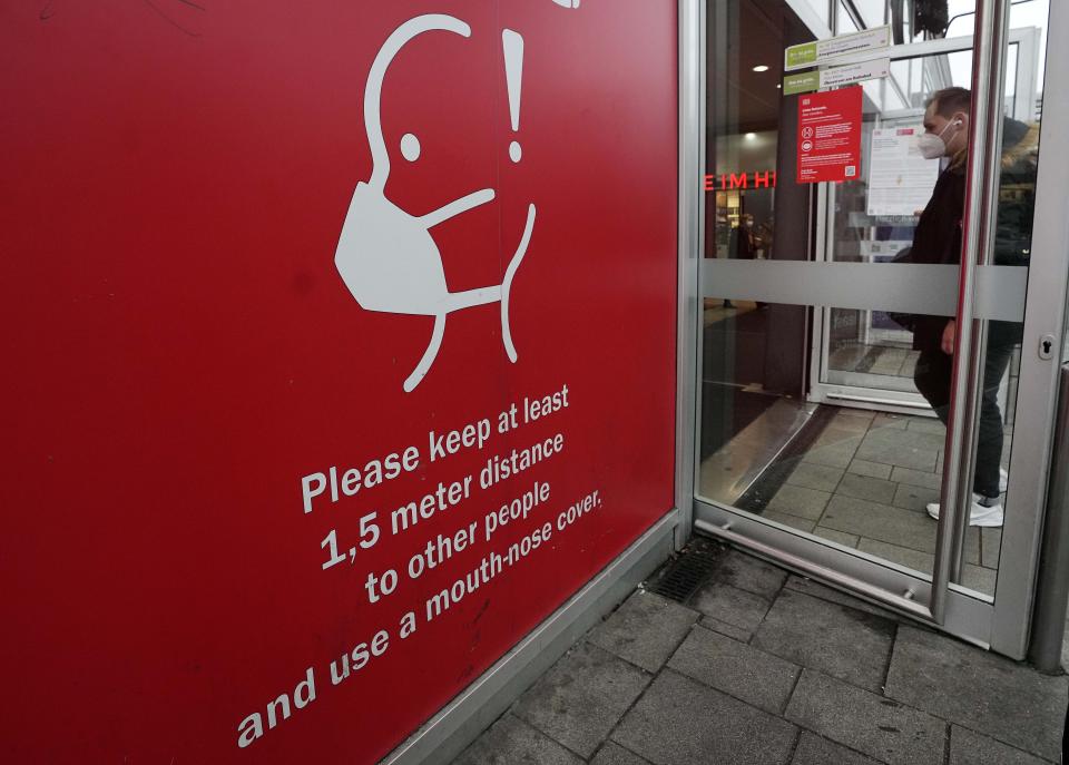 A sign reminds of mandatory face masks at the train station in Cologne, Germany, Wednesday, Nov. 17, 2021. Germany's disease control agency reported 52,826 new coronavirus cases Wednesday as infection rates continue to climb. (AP Photo/Martin Meissner)