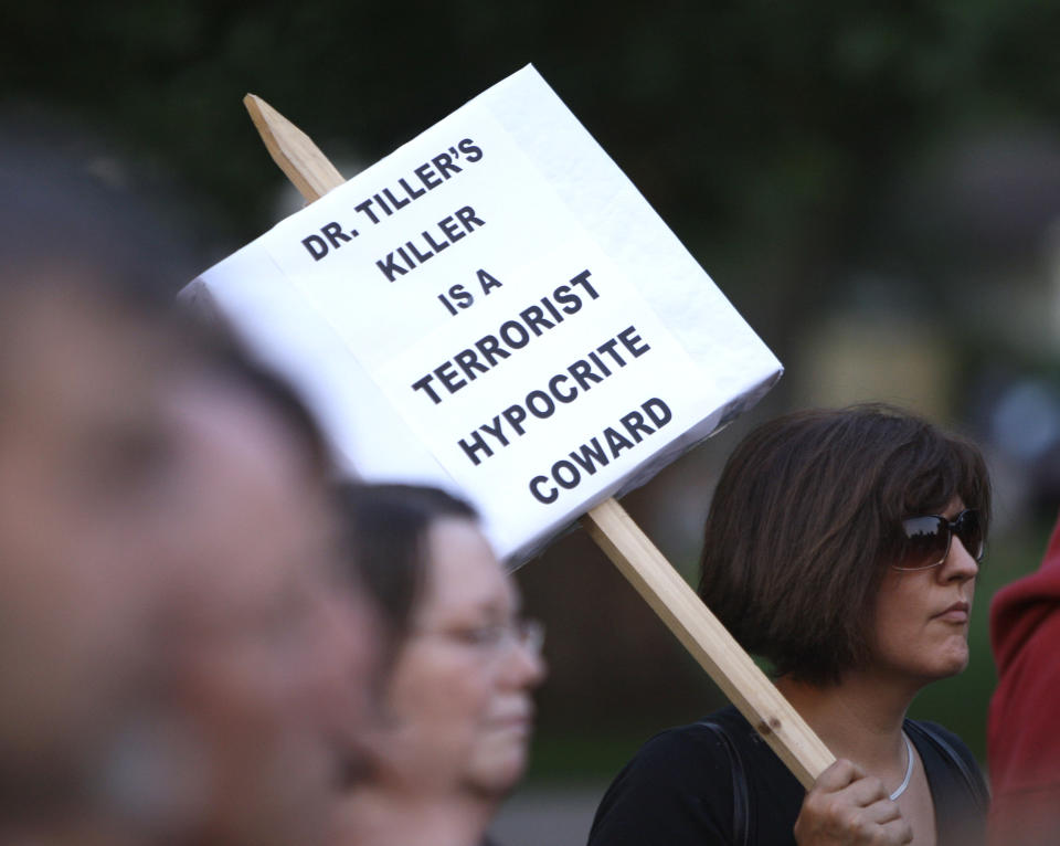 FILE - Janet FitzGerald holds a sign during a candlelight vigil for Dr. George Tiller at a park in Lawrence, Kan., on May 31, 2009. Tiller, one of the nation's few providers of late-term abortions despite decades of protests and attacks, was shot and killed during Sunday church serves. Harassment and violence have become common outside abortion clinics over the decades since the landmark 1973 ruling legalizing abortion. Now providers and some in law enforcement worry what will come next. (AP Photo/Charlie Riedel, File)