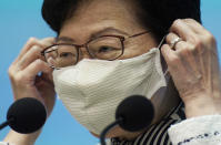 Hong Kong Chief Executive Carrie Lam adjusts the face mask during a press conference on the state of the coronavirus in Hong Kong, Tuesday, Sept. 1, 2020. Hong Kong kicked off a voluntary mass-testing program for coronavirus Tuesday as part of a strategy to break the chain of transmission in the city's third outbreak of the disease. (AP Photo/Vincent Yu)