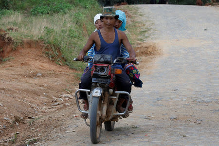 People ride their motorbike as they travel outside Panghsang capital city of ethnic Wa territory in northeast Myanmar October 3, 2016. REUTERS/Soe Zeya Tun