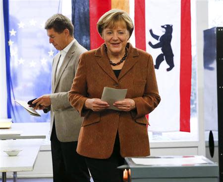 German Chancellor Angela Merkel and her husband Joachim Sauer prepare to vote in the German general election (Bundestagswahl) at a polling station in Berlin, September 22, 2013. REUTERS/Fabrizio Bensch (GERMANY - Tags: POLITICS ELECTIONS)