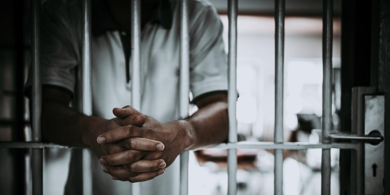 Midsection Of Man Standing In Prison - stock photo