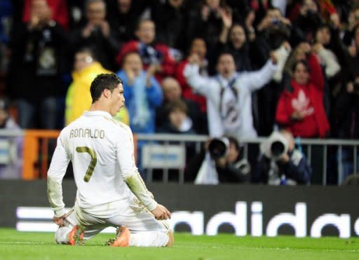 Real Madrid's forward Cristiano Ronaldo celebrates after scoring against Sporting Gijon at the Santiago Barnabeu stadium in Madrid. Ronaldo set a new La Liga scoring record and Real Madrid equalled the highest ever goal tally in a season as they came from behind to beat Sporting Gijon 3-1 and open a seven-point lead over Barcelona