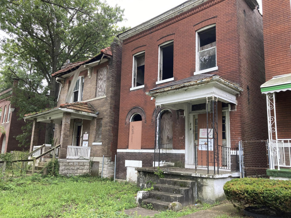 Two condemned homes sit in ruins just a block from the site of the old Homer G. Phillips Hospital in St. Louis, Mo., on Aug. 9, 2022. Black leaders say that the once-vibrant neighborhood deteriorated badly when the city shut down the 660-bed hospital in 1979. (AP Photo/Jim Salter)