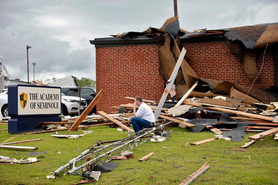 Surrounded by tornado damage, Paul Campbell, founder of The Academy of Seminole sits outside of the school on Thursday after a tornado slammed the school and the town Wednesday night.