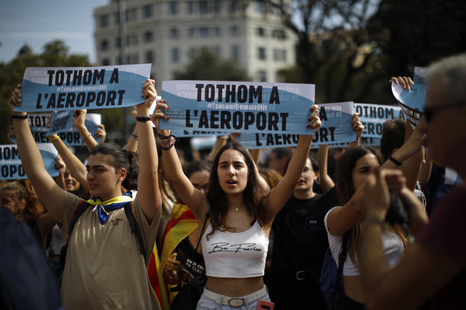 Young people hold up signs in Catalan reading "Everybody to the airport" during protests in Barcelona, Spain, Monday, Oct. 14, 2019. Spain's Supreme Court on Monday convicted 12 former Catalan politicians and activists for their roles in a secession bid in 2017, a ruling that immediately inflamed independence supporters in the wealthy northeastern region. (AP Photo/Emilio Morenatti)