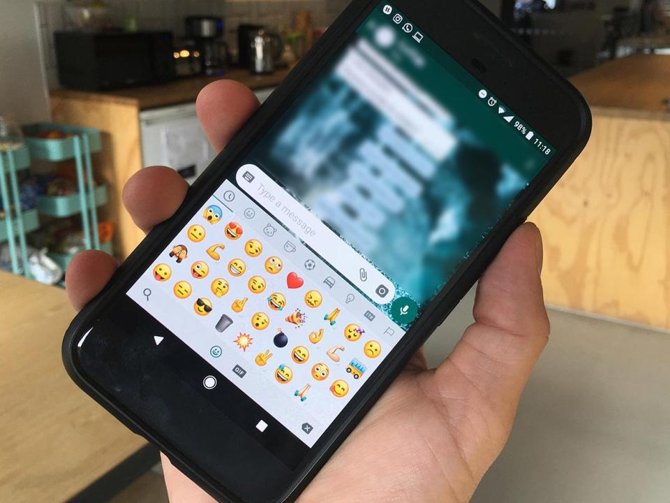 WhatsApp emoji displayed on a phone screen.