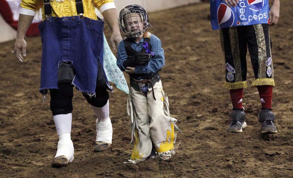 CeJay Jones, 6, grimaces and holds his elbow after falling in the mini bull riding competition at the 108th National Western Stock Show in Denver January 11, 2014. The show, which features more than 15,000 head of livestock, opened on Saturday and runs through January 26. REUTERS/Rick Wilking (UNITED STATES - Tags: ANIMALS SOCIETY)