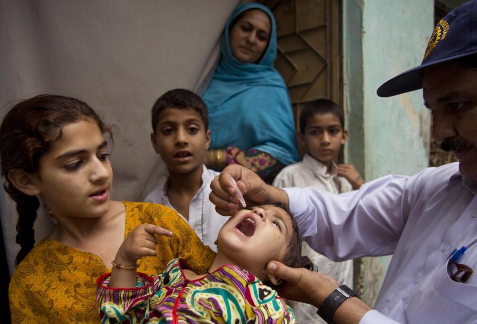 A Pakistani health worker gives a polio vaccine to a child in Rawalpindi, Pakistan, Tuesday, May 6, 2014. Pakistan’s health minister says the country is taking extra ordinary measures to meet the new situation it is going to face after polio travel restrictions. (AP Photo/B.K. Bangash)