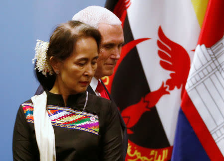 U.S. Vice President Mike Pence passes by Myanmar’s leader Aung San Suu Kyi as he arrives for a group photo with ASEAN leaders at the ASEAN-U.S. Summit in Singapore November 15, 2018. REUTERS/Edgar Su