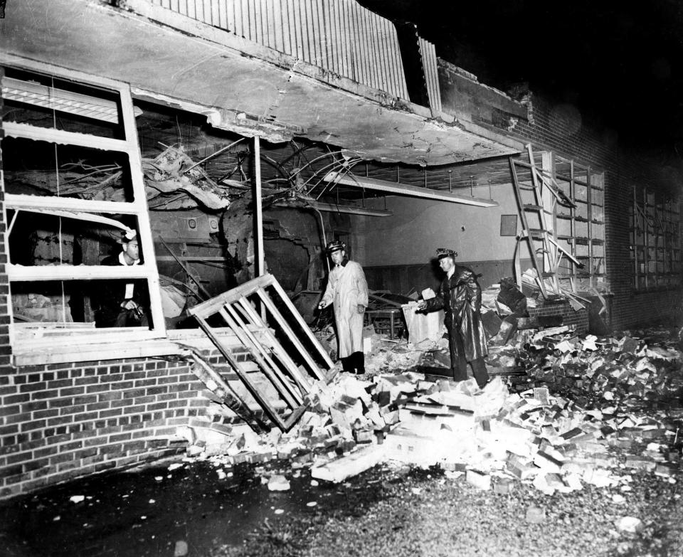 Nashville police Sgt. John Irwin, center, and two other officers search for clues after a dynamite blast tore a huge hole in a wall at Hattie Cotton Elementary School on Sept. 10, 1957.