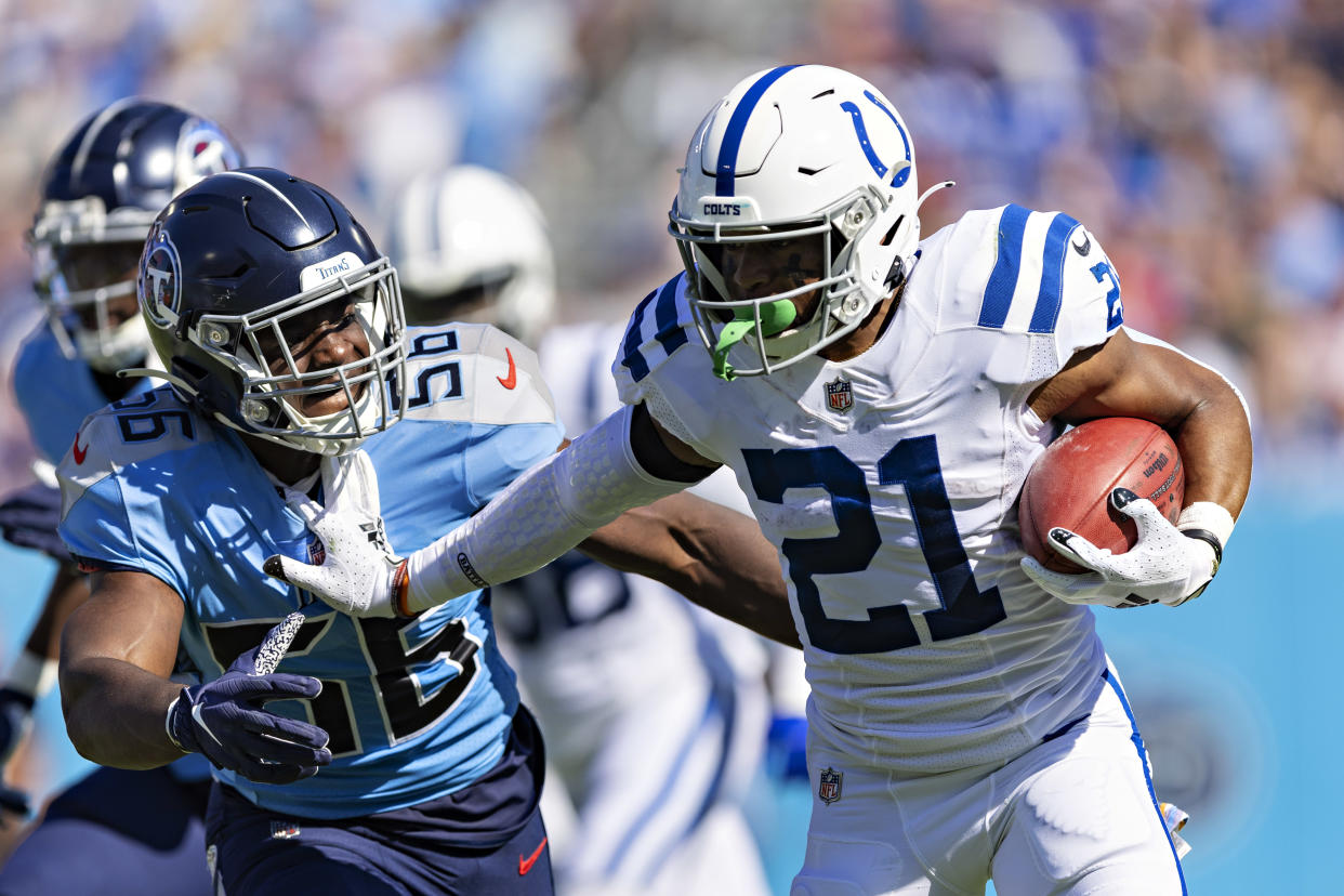 NASHVILLE, TENNESSEE - OCTOBER 23: Nyheim Hines #21 of the Indianapolis Colts runs the ball and throws a stiff arm on Monty Rice #56 of the Tennessee Titans at Nissan Stadium on October 23, 2022 in Nashville, Tennessee. The Titans defeated the Colts 19-10. (Photo by Wesley Hitt/Getty Images)