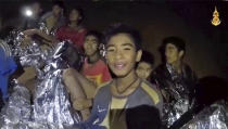 <p>In this July 3, 2018, image taken from video provided by the Royal Thai Navy Facebook page, Thai boys smile as Thai navy SEAL medics help them inside a cave in Mae Sai, northern Thailand. The Thai soccer teammates, who were stranded for more than a week in the partially flooded cave, said they were healthy in a video released on July 4, as a forecast of heavy rains complicated plans to safely extract them. (Photo: Royal Thai Navy Facebook via AP) </p>