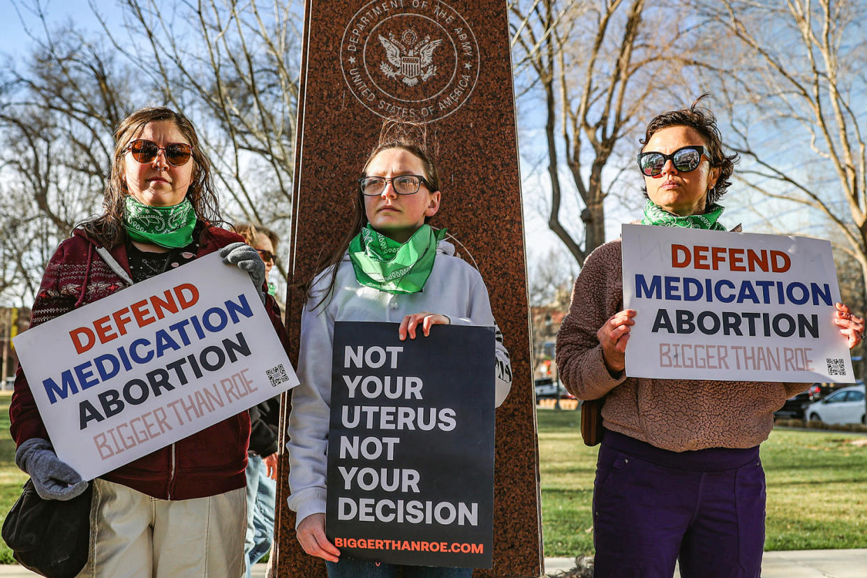 Three members of the Women's March group protest in support of access to abortion medication (David Erickson / AP file)