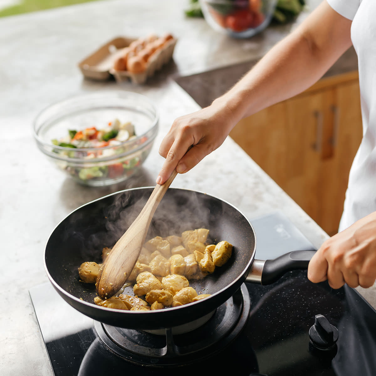 woman sauteeing food in pan