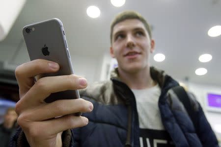 A customer holds the newly released iPhone 6 at a mobile phone shop in Moscow, September 26, 2014. REUTERS/Maxim Shemetov/Files