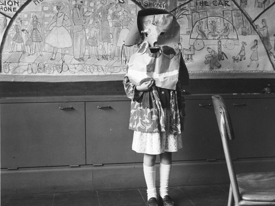 little girl dressed in vintage mask costume in black and white