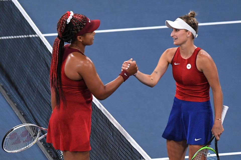 Naomi Osaka (left) shakes hands with Markéta Vondroušová.