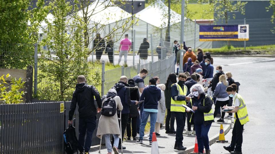 Menschen warten in einer Schlange vor dem mobilen Covid-Impfzentrum an der ESSA-Akademie in Bolton.