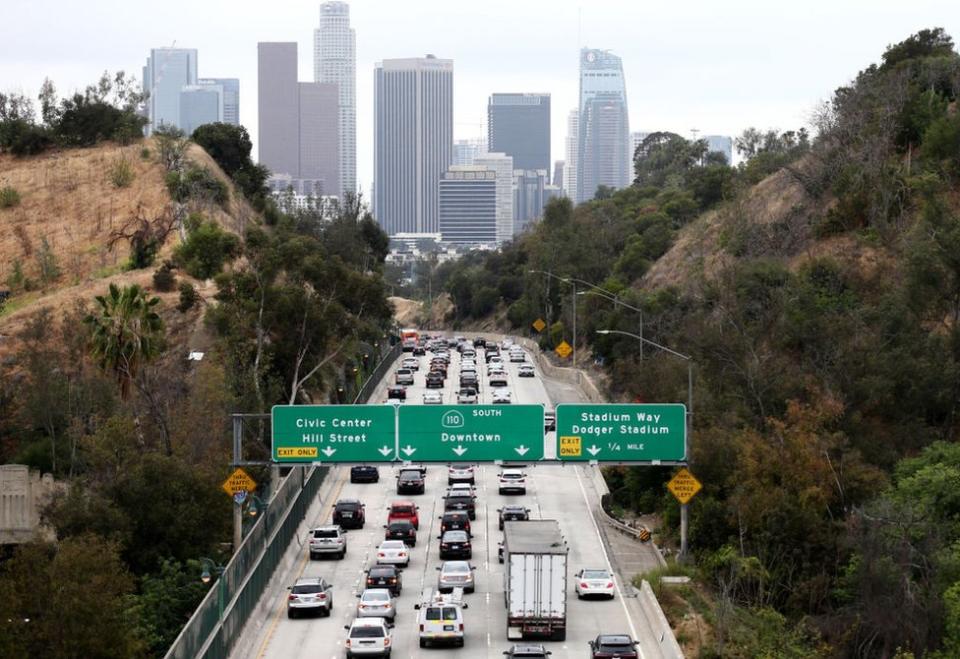 Atasco en la autopista con el Downtown de Los Ángeles al fondo.