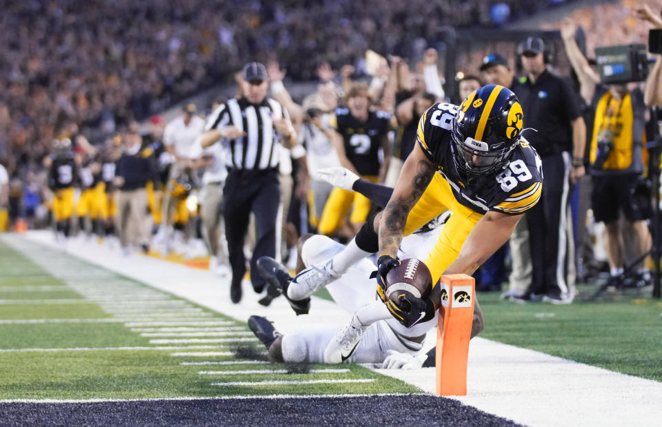 Iowa wide receiver Nico Ragaini (89) dives to score a touchdown in front of Penn State safety Ji'Ayir Brown (16) during the second half of an NCAA college football game, Saturday, Oct. 9, 2021, in Iowa City, Iowa. Iowa won 23-20. (AP Photo/Matthew Putney)