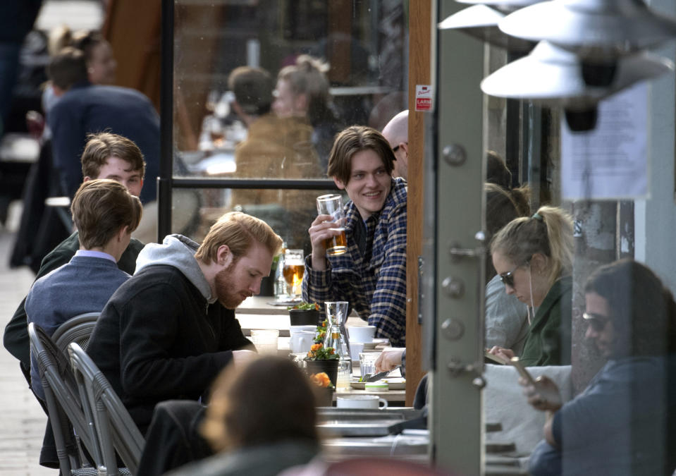 People enjoy themselves at an outdoor restaurant, amid the coronavirus outbreak, in central Stockholm, Sweden, Monday April 20, 2020. (Anders Wiklund/TT News Agency via AP)