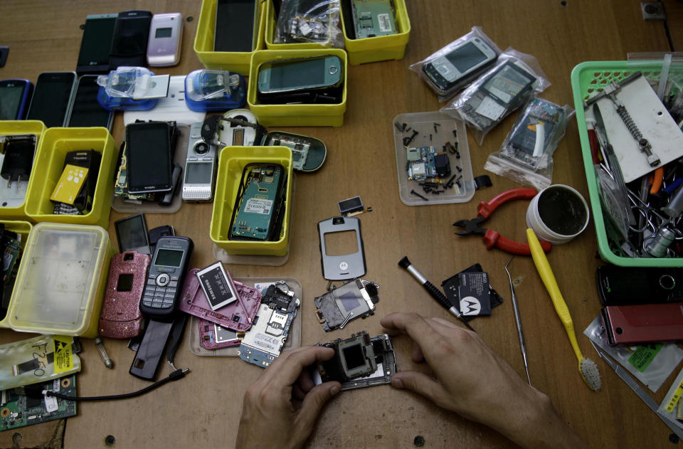 Javier E. Matos repairs a a cell phone at The Cell Phone Clinic, a private business in Havana, Cuba, Thursday, Aug. 30, 2012. A jump in import taxes on Monday, Sept. 3 threatens to make life tougher for some of Cuba's new entrepreneurs who the government has been trying to encourage as it cuts a bloated workforce in the socialist economy. In Cuba, the average monthly wage is about $20. (AP Photo/Franklin Reyes)